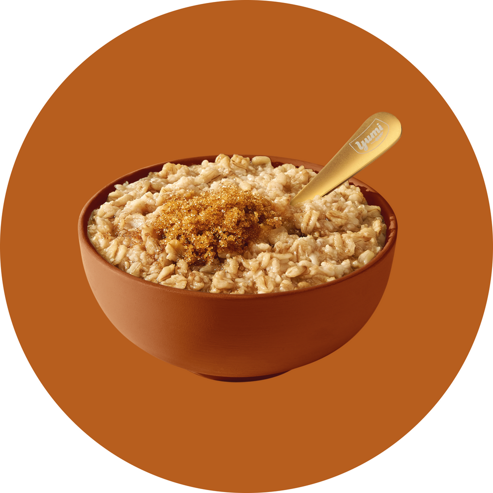 Bowl of oatmeal with a spoon on a brown background
